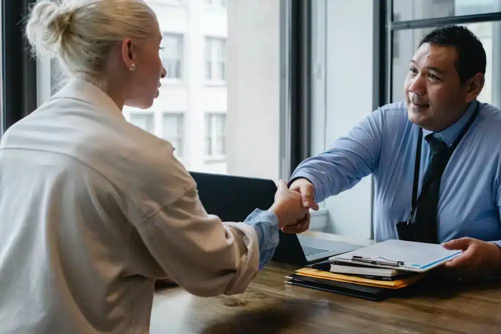 A business handshake between a client and a private investigator from Hanuman Investigation.